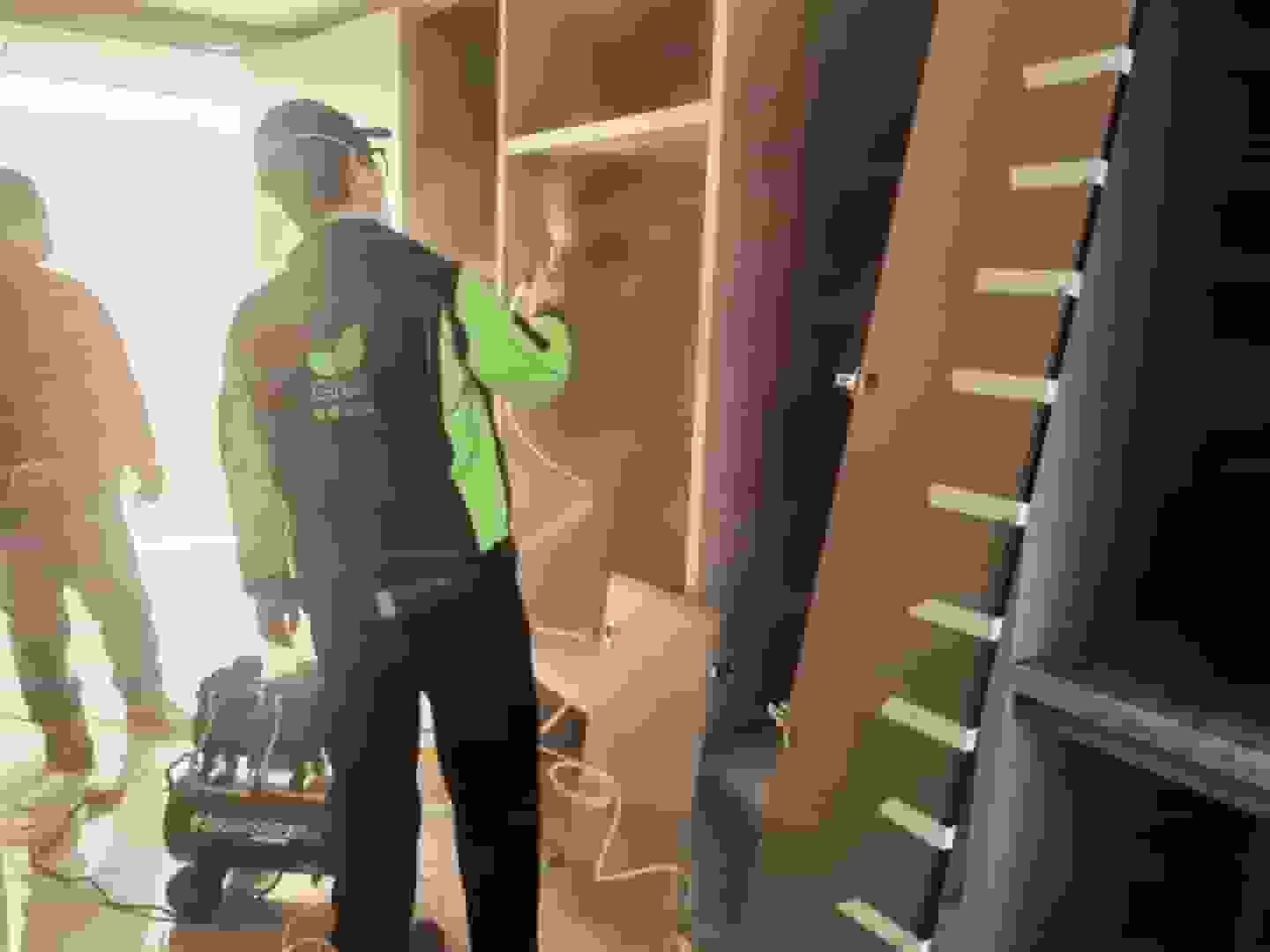 圖片里，格瑞樂專業(yè)檢測人員身著統(tǒng)一工作服，手持先進的甲醛檢測儀器，站在擺滿新家具的客廳中央，全神貫注地檢測空氣中的甲醛含量，為后續(xù)除醛工作采集關(guān)鍵數(shù)據(jù)。